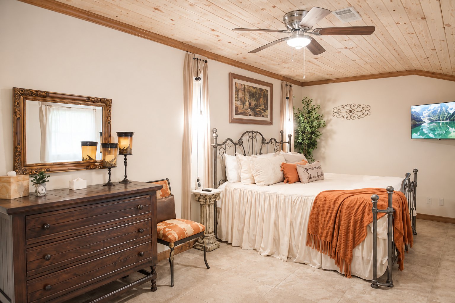 Villa Serena master bedroom with an iron bed and orange throw